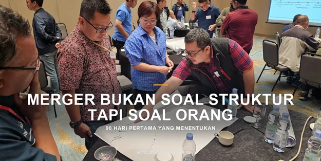 Apa Itu Organizational Alignment dan Cara Mengukurnya – gambar unggulan Dua orang membaca rencana kerja bersama di meja, menggambarkan keselarasan arah dan peran di organisasi